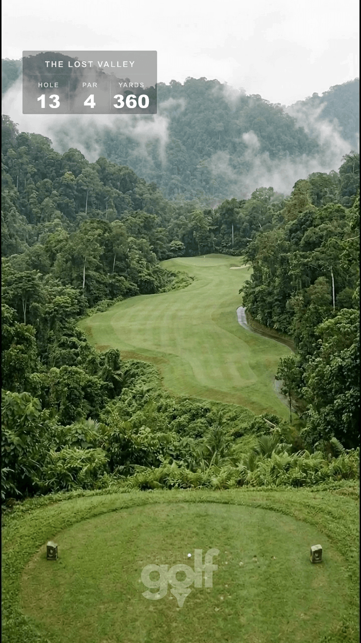 AI-imagined golf hole: a par 4 tumbling down a misty rainforest valley, doglegging to a green tucked under the mountainside